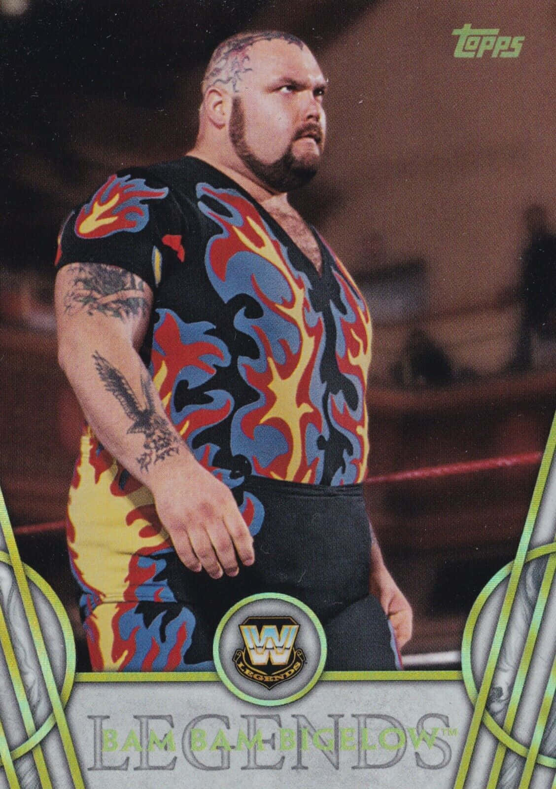 WWE 桌布 壁紙 — Bam Bam Bigelow 站在摔角擂台上，身穿帶有醒目紅、藍、黃火焰圖案的黑色襯衫和黑色短褲。