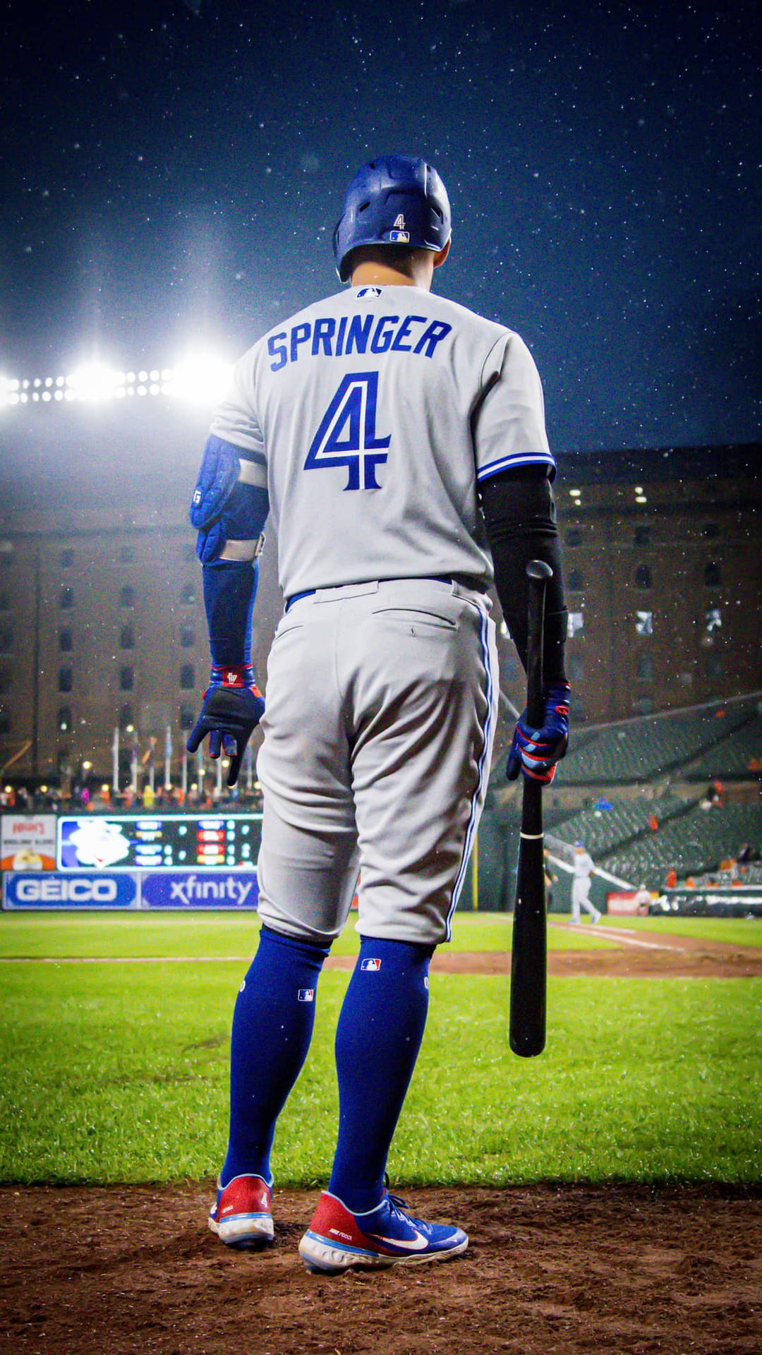 身穿Springer球衣的棒球選手在夜晚的體育場燈光下站在球場上。 — MLB 壁紙