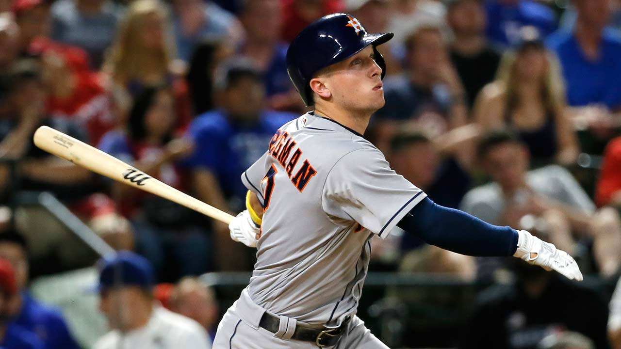 夜間比賽中揮棒的棒球選手，背景有觀眾。 — MLB 壁紙