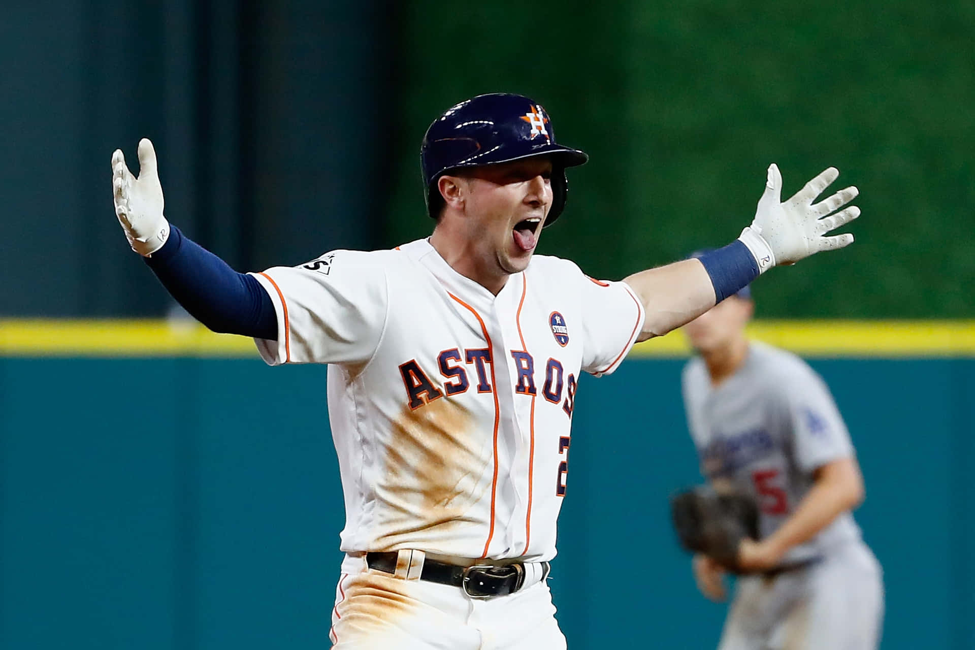 棒球選手在夜間比賽中高舉雙臂慶祝勝利。 — MLB 壁紙