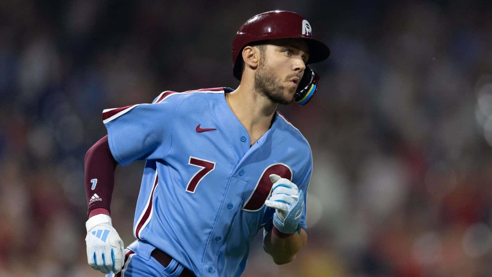 Trea Turner Phillies 桌布 壁紙 — 一名身穿淺藍色7號球衣的棒球運動員在明亮的燈光下衝過球場。