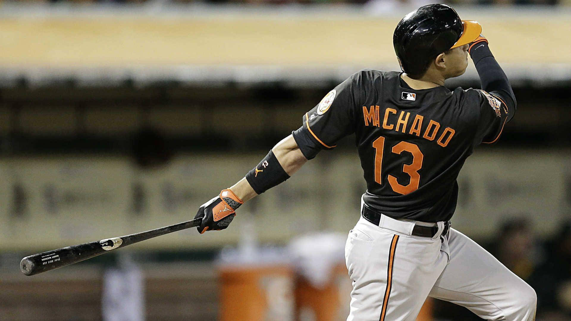 棒球運動員在夜間比賽中於球場燈光下揮棒。 — MLB 壁紙
