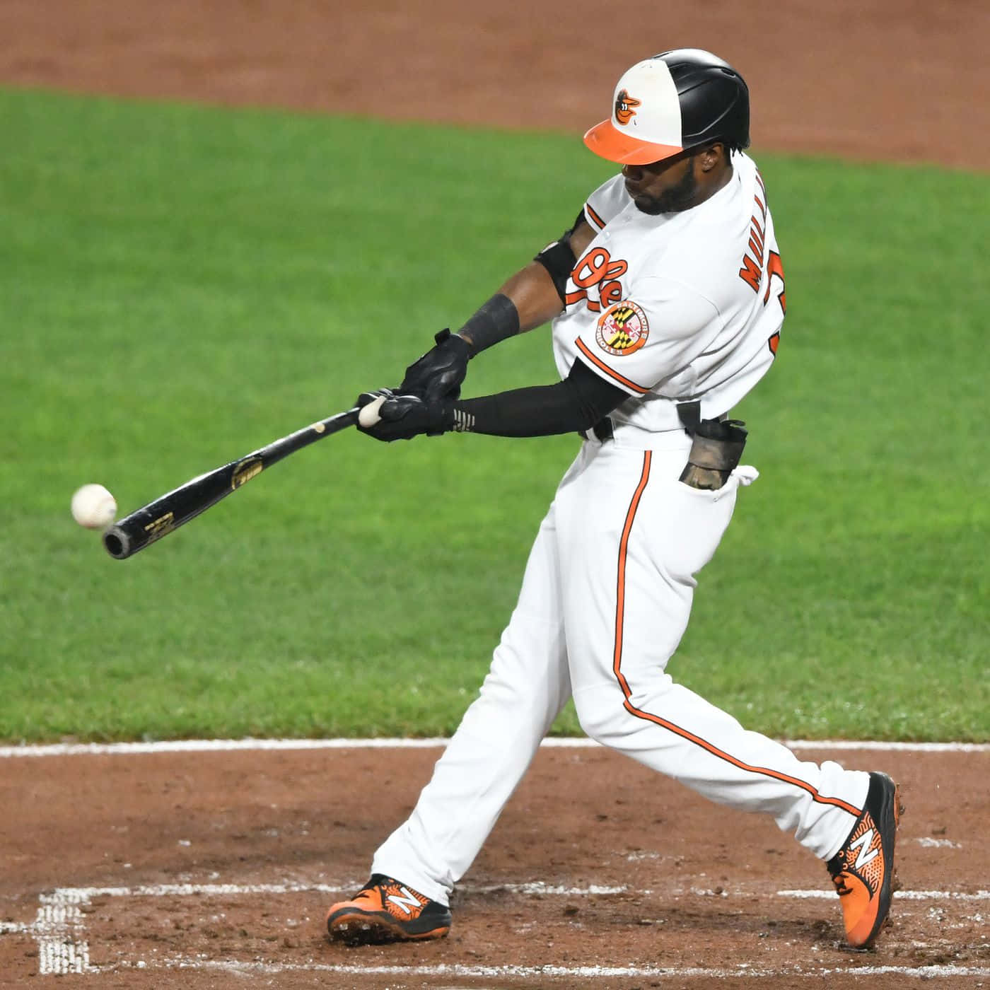 棒球選手在夜間比賽中揮棒擊球。 — MLB 壁紙