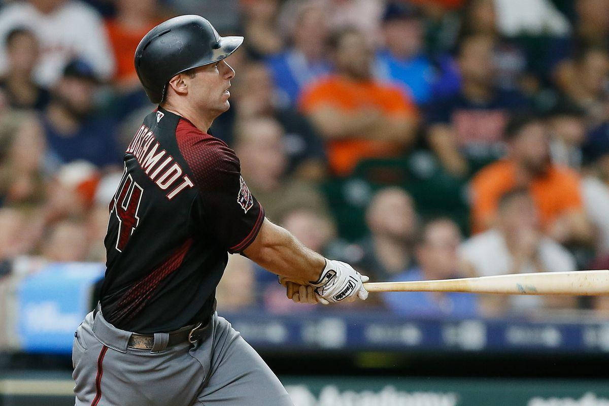 夜間比賽中揮棒的棒球選手，背景有觀眾。 — MLB 壁紙