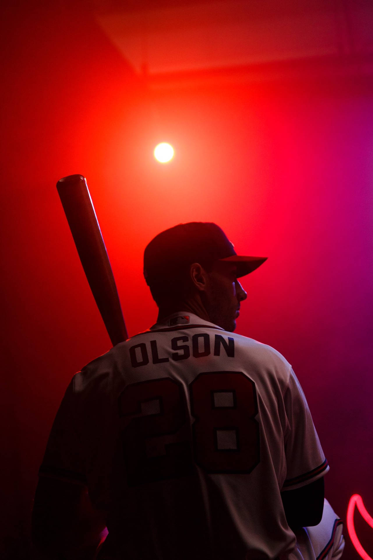 身穿28號球衣的Olson在紅光下手持球棒的棒球選手。 — MLB 壁紙