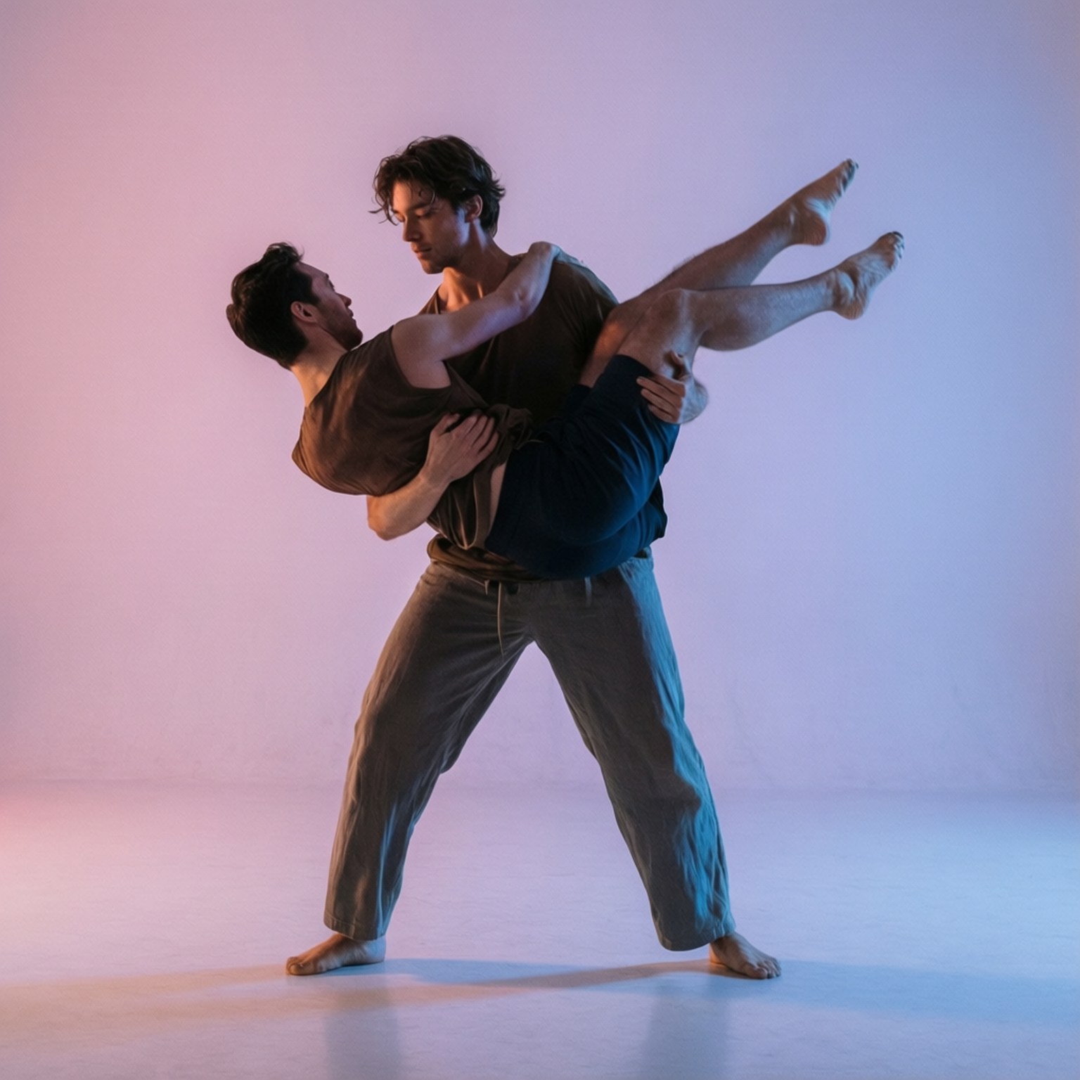 Modern Dance Lift 壁紙 — 兩名赤腳男子身穿柔和服裝，在柔和粉紅和藍色漸變的攝影棚牆前進行動態舞蹈托舉。