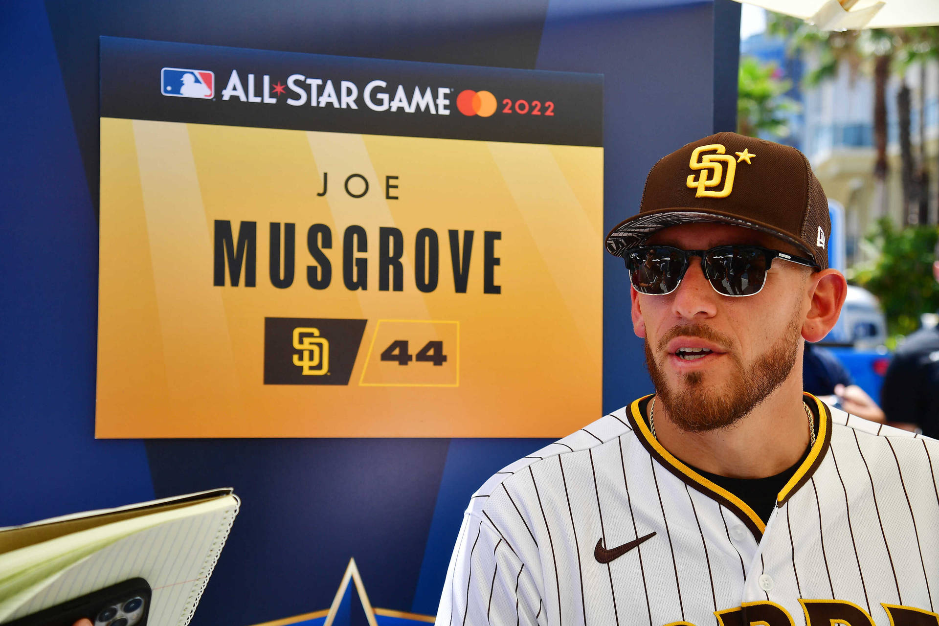 棒球運動員 Joe Musgrove 身穿教士隊制服和太陽眼鏡，出席全明星賽活動。 — MLB 壁紙
