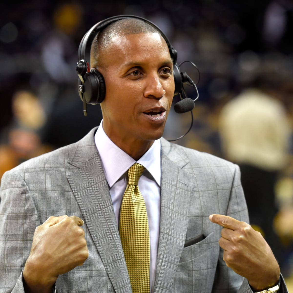 身穿西裝和耳機的籃球教練在比賽中做手勢。 — NBA 壁紙