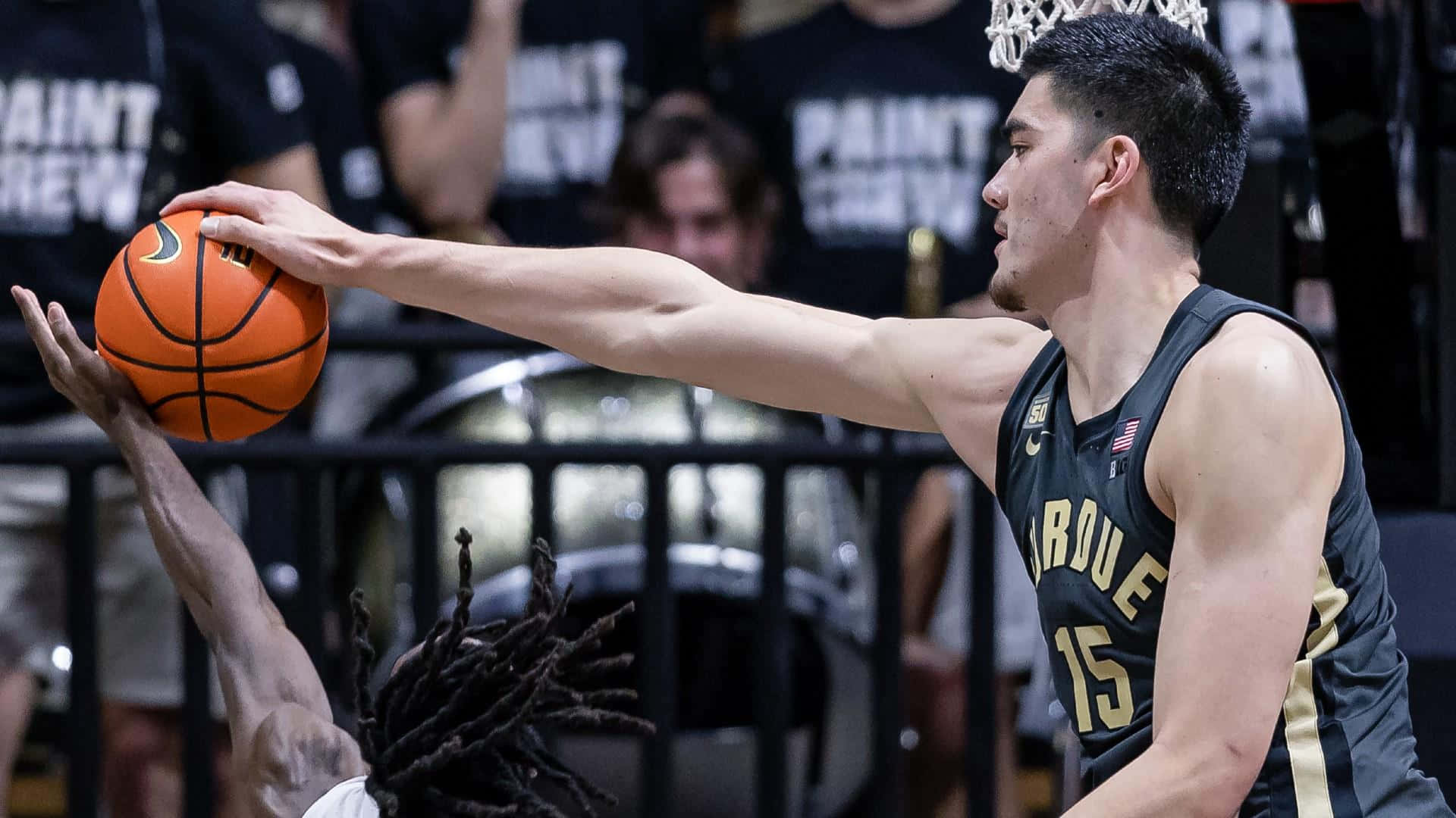 籃球運動員在比賽中封阻投籃，背景有觀眾。 — NBA 壁紙
