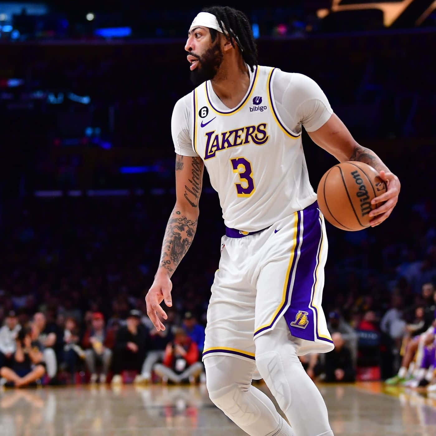 職業籃球運動員穿著湖人隊球衣在比賽中運球。 — NBA 壁紙