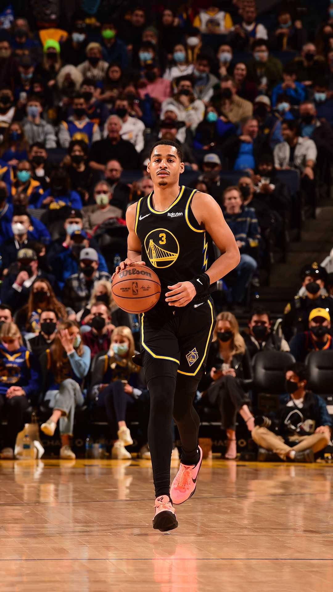 籃球運動員在比賽中運球，周圍有戴口罩的觀眾。 — NBA 壁紙