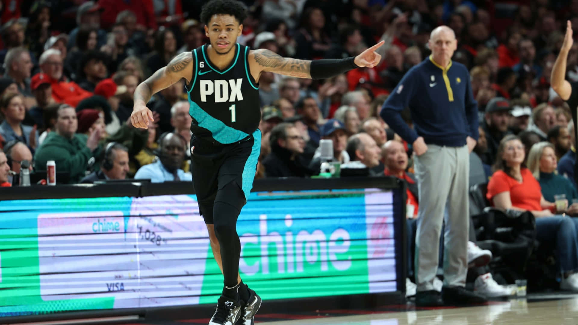 身穿PDX球衣的籃球運動員運球並指向觀眾。 — NBA 壁紙
