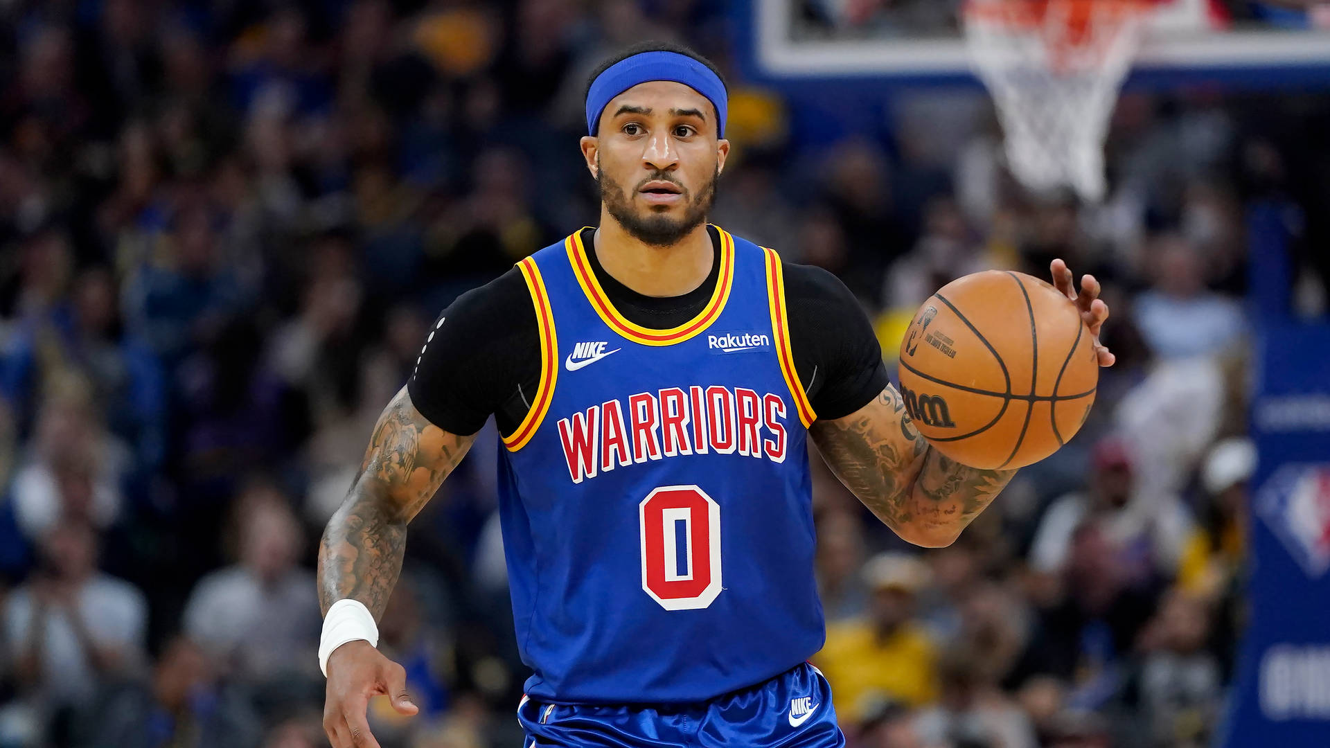 身穿藍色勇士隊球衣的職業籃球運動員在比賽中運球。 — NBA 壁紙