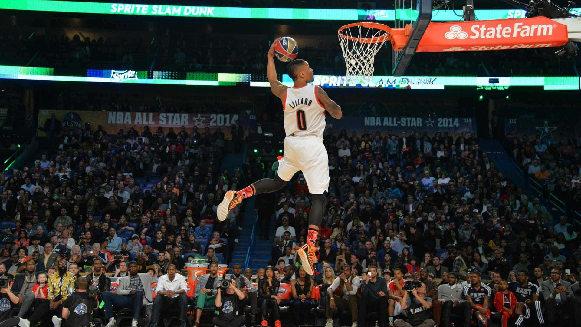  壁紙 — 在明亮的場館燈光下，一名籃球運動員在2014年NBA全明星賽灌籃大賽中空中灌籃。