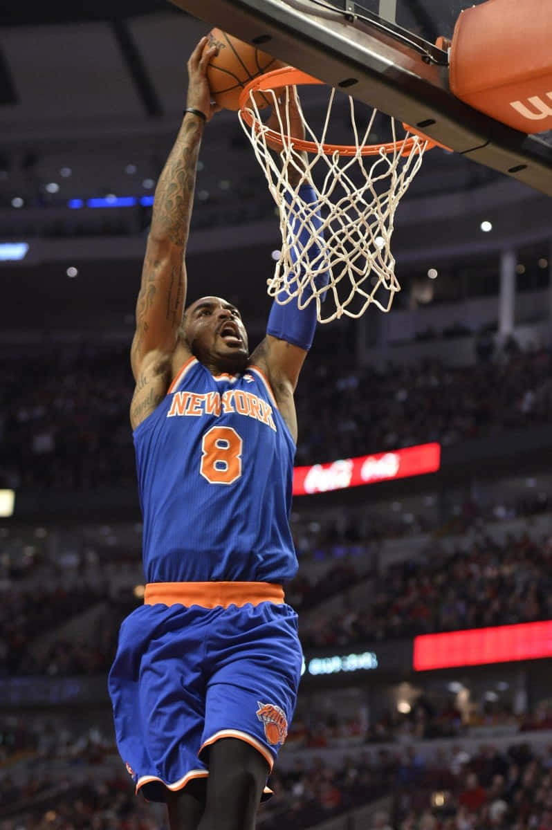 身穿藍色尼克隊球衣的籃球運動員在場館中灌籃。 — NBA 壁紙