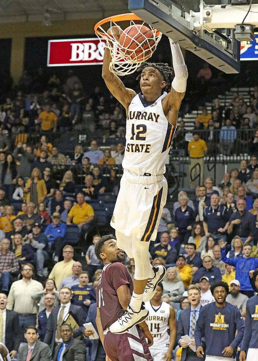  壁紙 — 一名身穿白色 Murray State 球衣的籃球運動員在擠滿觀眾的場館內大力灌籃，防守球員在下方觀望。