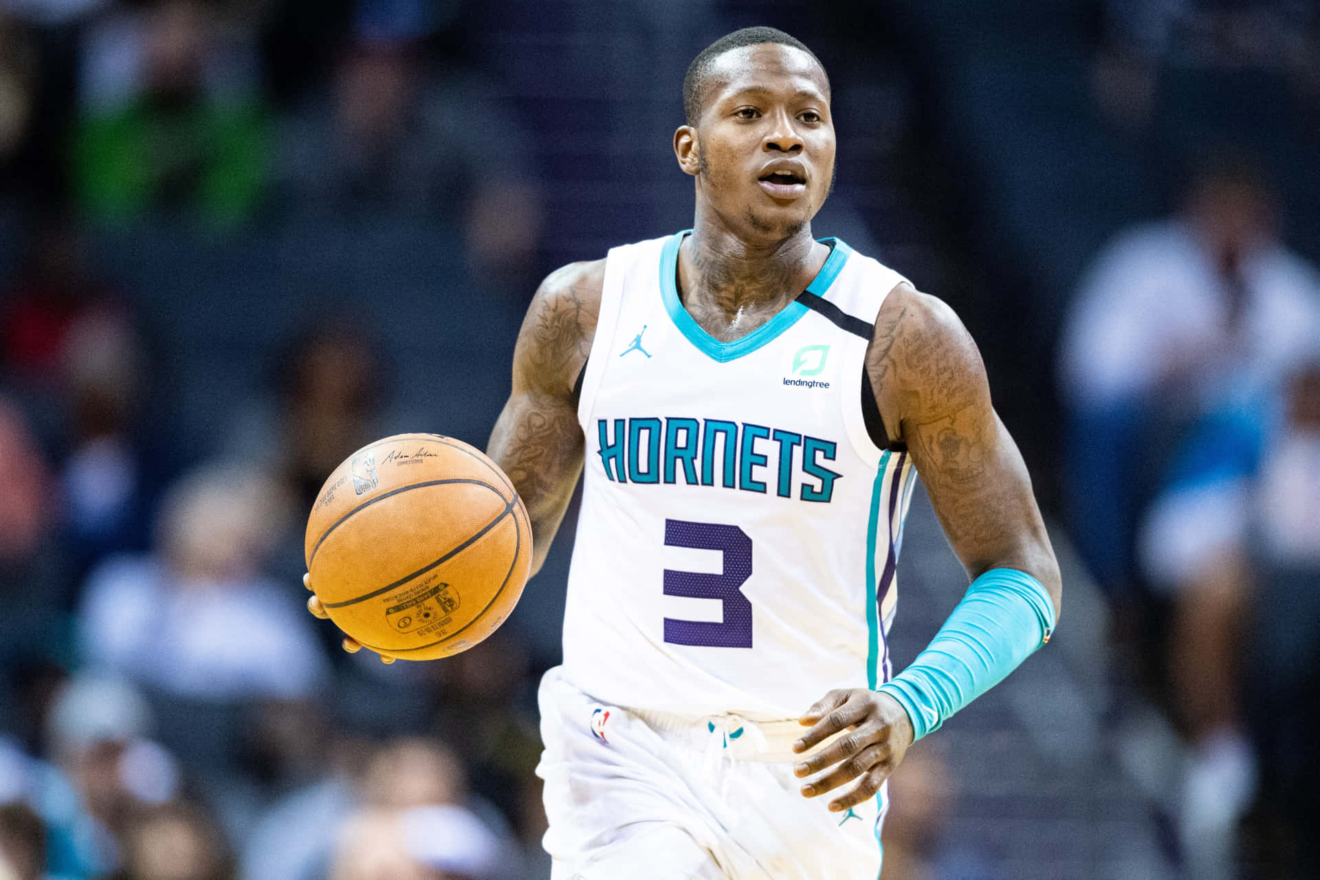 職業籃球運動員在比賽中穿著黃蜂隊球衣運球。 — NBA 壁紙
