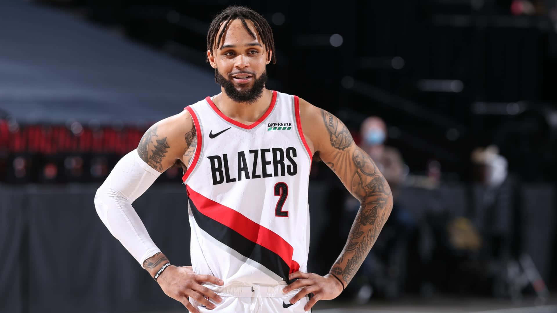 身穿拓荒者球衣的職業籃球運動員，在球場上雙手叉腰站立。 — NBA 壁紙