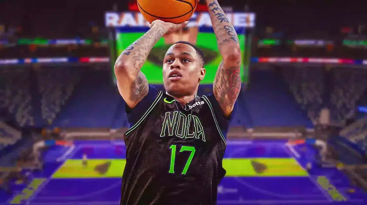  壁紙 — 一名穿著黑色 'NOLA 17' 球衣的籃球運動員在一個燈光明亮、帶有紫色和綠色場地標記的體育館中投籃。