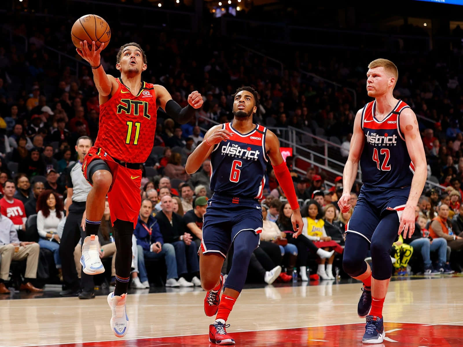 籃球運動員在比賽中越過兩名防守者投籃。 — NBA 壁紙