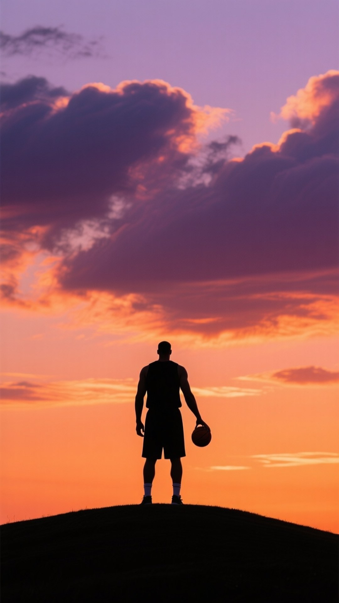 Sunset Silhouette 壁紙 — 一個籃球運動員的剪影站在山頂上，手持籃球，而充滿活力的紫色、橙色和粉紅色雲彩在日落時分發光。