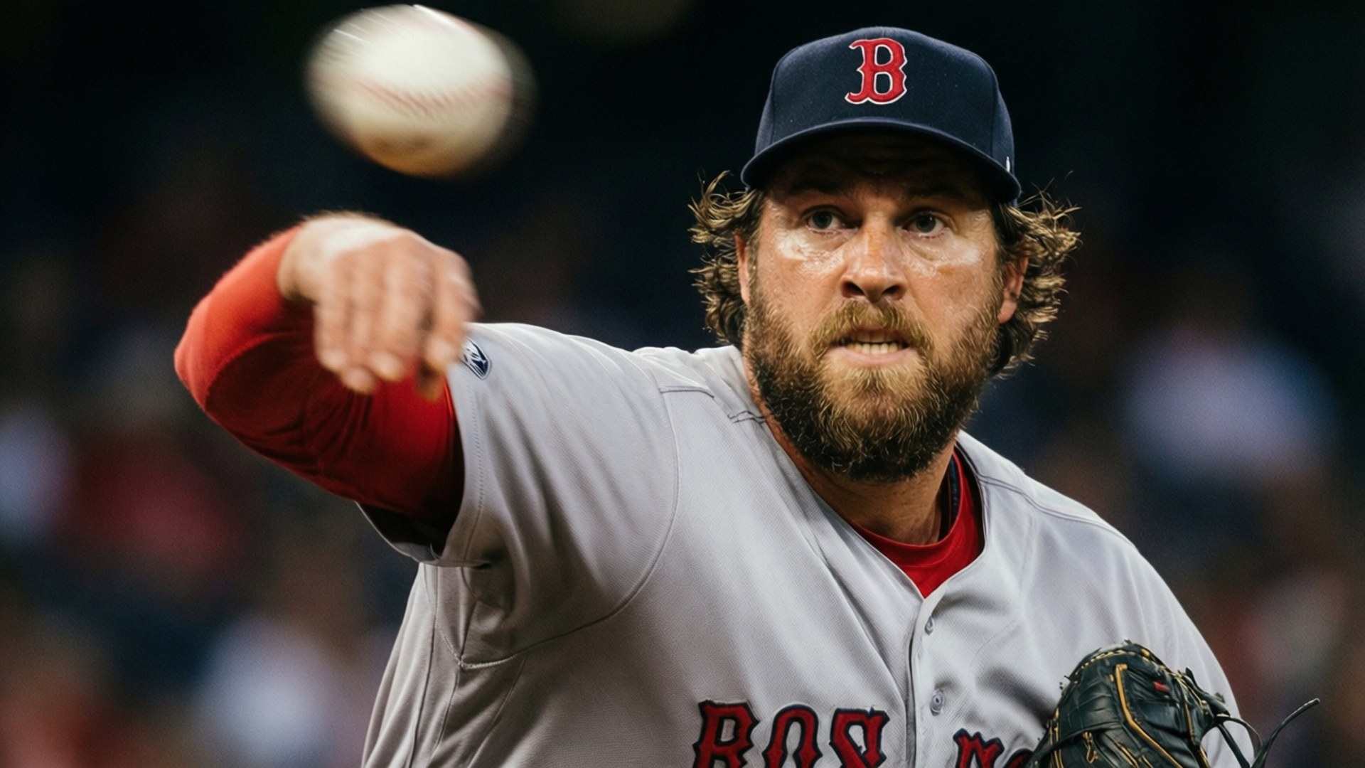 Boston Red Sox 桌布 壁紙 — 一名留鬍鬚的棒球投手身穿波士頓球衣，在黑暗的球場背景下投球，球體模糊移動。