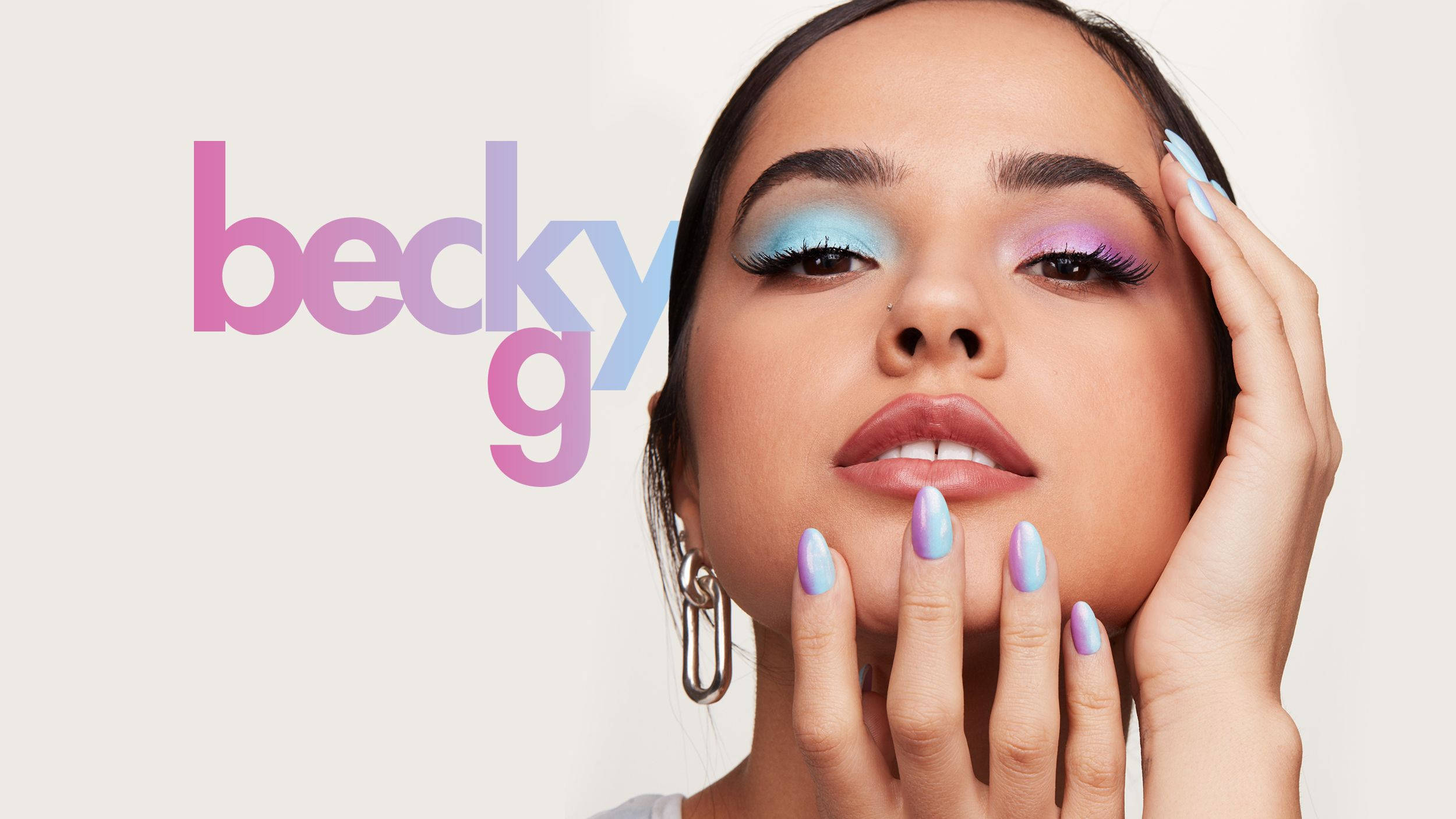 g 桌布 壁紙 — Becky G 以鮮豔的藍色和紫色眼影及相配的指甲在柔和漸變背景前擺姿勢。