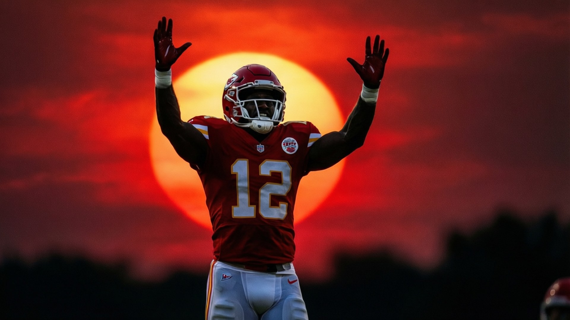 Touchdown Silhouette 壁紙 — 一名身穿紅色球衣、背號12的足球運動員，在熾熱的橙紅色日落中高舉雙臂慶祝勝利。