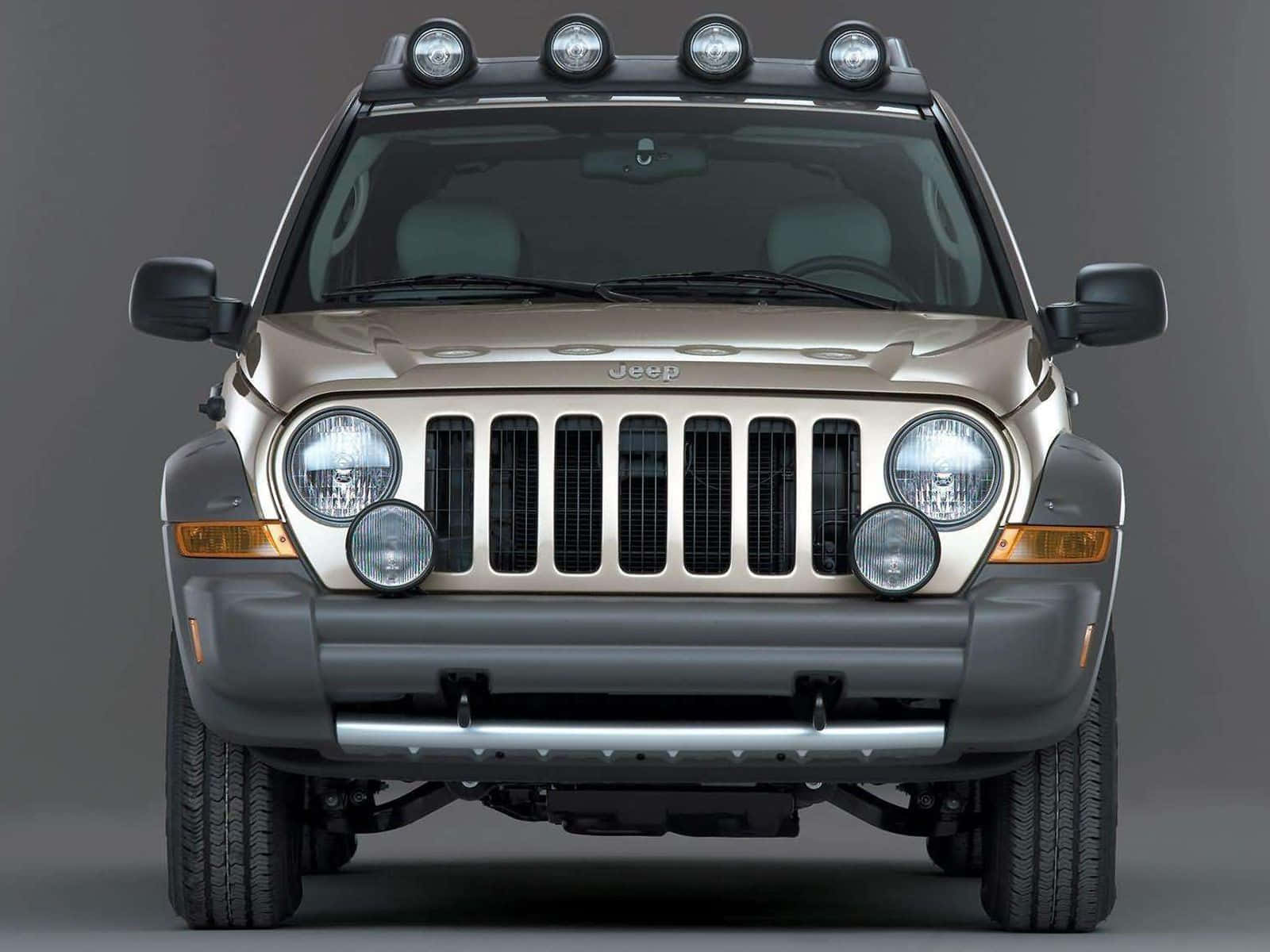 Jeep Liberty 桌布 壁紙 — 米色Jeep Wrangler正面視圖，配備車頂探照燈和鍍鉻格柵，背景為灰色工作室。