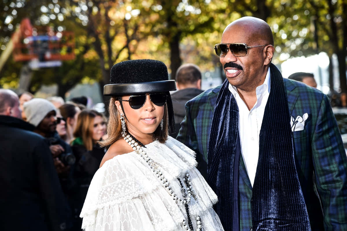 Sunglasses 桌布 壁紙 — Beyoncé 和 Jay-Z 在金色陽光下，戴著時尚太陽眼鏡和穿著大膽服裝，漫步於秋樹之間。