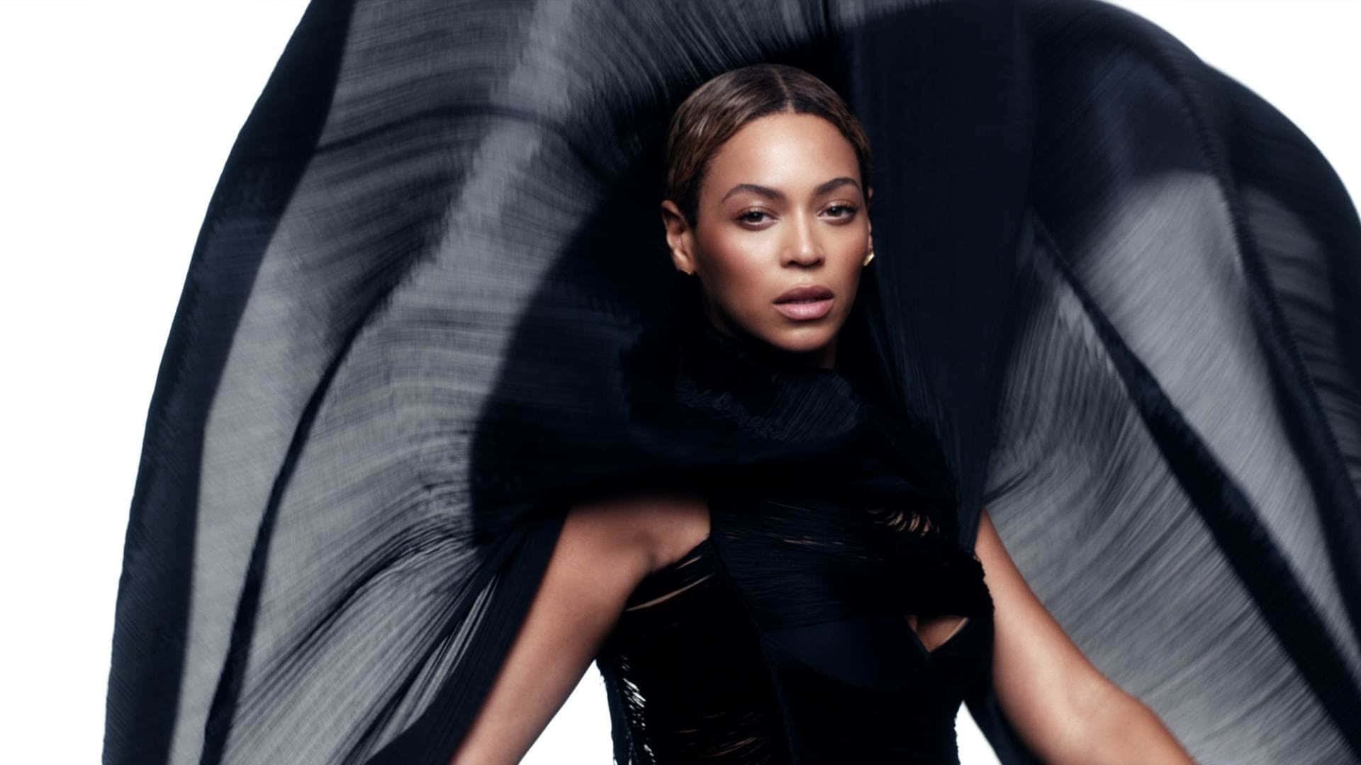 碧昂絲 桌布 壁紙 — Beyoncé 強烈凝視，被戲劇性飄逸的黑色布料框住，背景是純白色。
