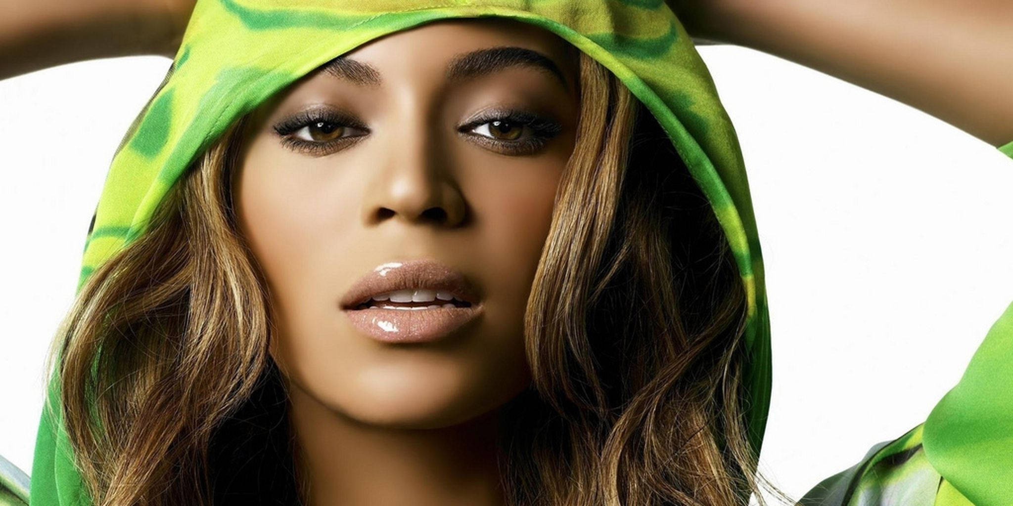 碧昂絲 桌布 壁紙 — Beyoncé 穿著綠色紮染連帽衫，襯托著她的臉，在純白背景下強烈凝視。