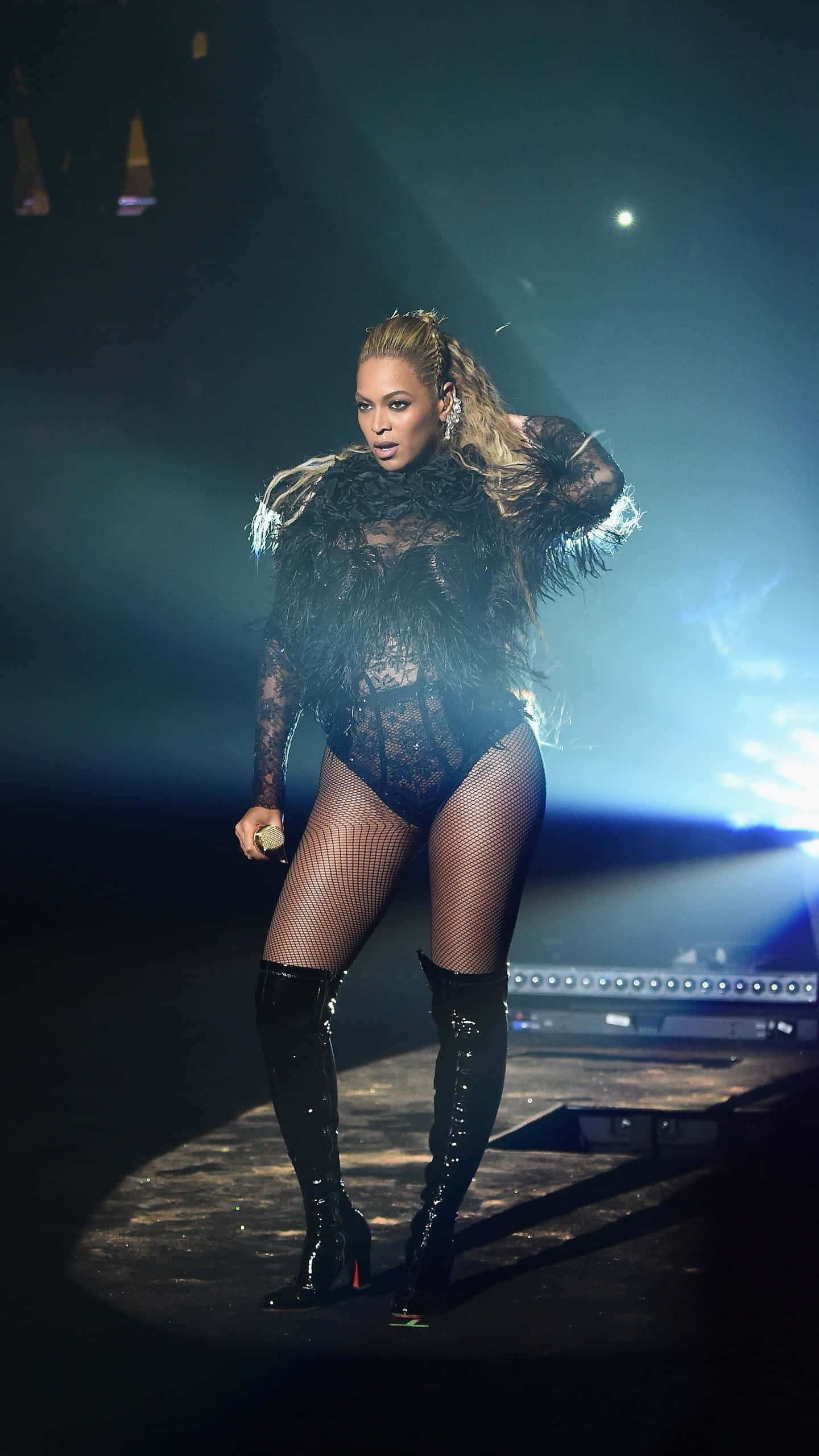 音樂 桌布 壁紙 — Beyonce 在戲劇性的藍色聚光燈下，身穿黑色蕾絲連體衣和過膝長靴，主宰舞台。