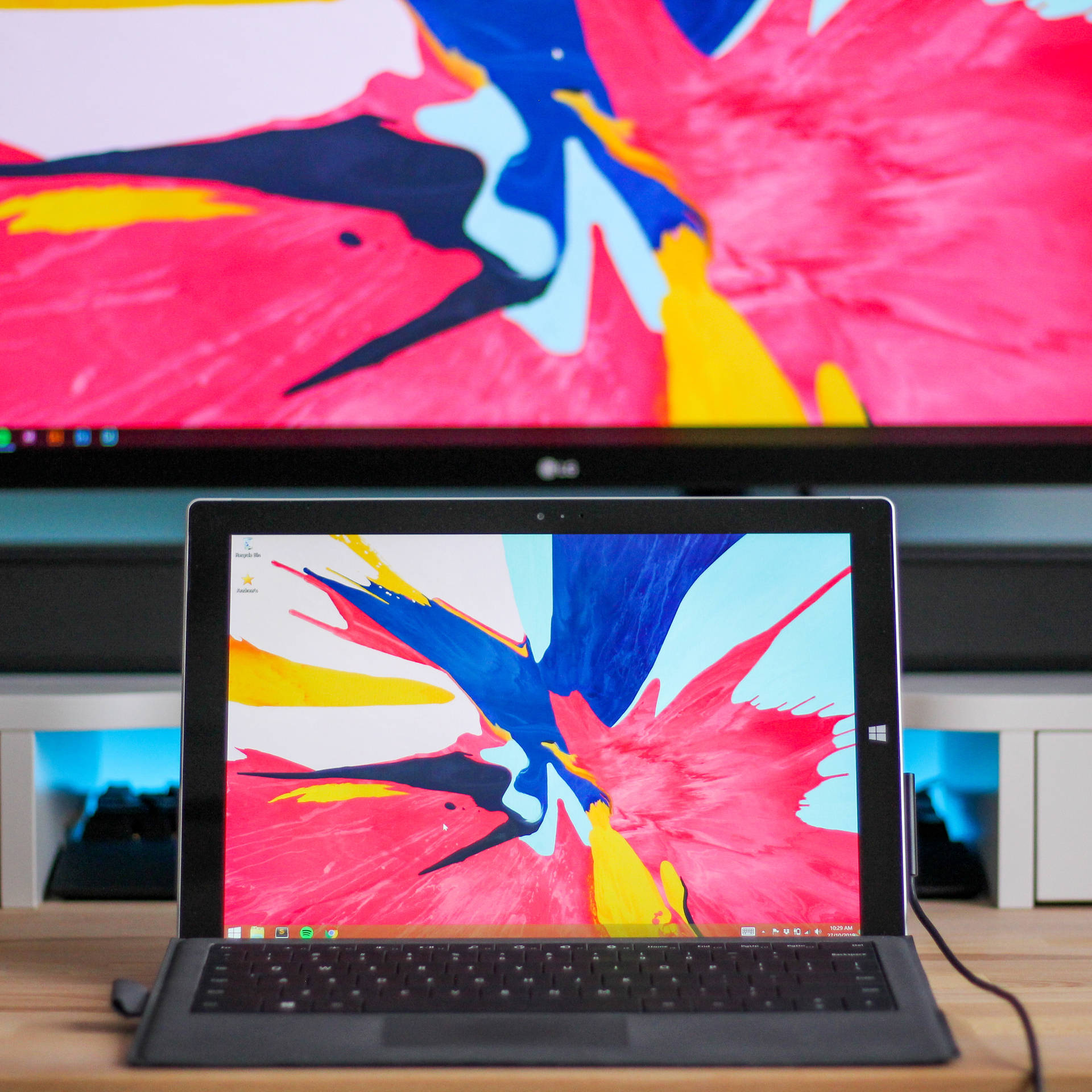 筆記型電腦和顯示器在木桌上展示色彩繽紛的抽象壁紙 — Windows 11 壁紙
