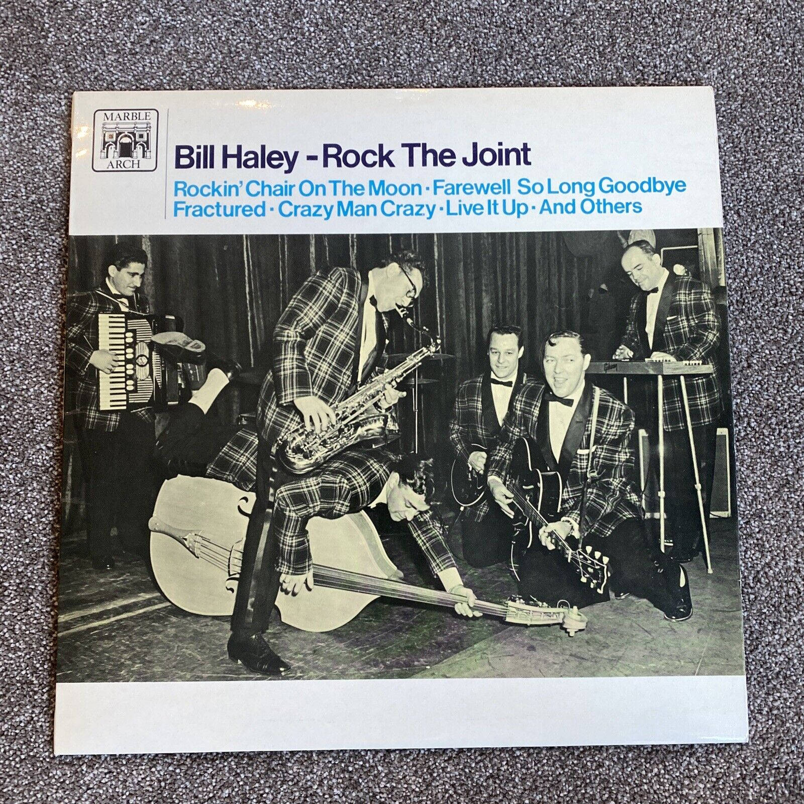 band 桌布 壁紙 — Bill Haley and his Comets 穿著格紋西裝在舞台上用樂器現場表演的復古黑白照片。