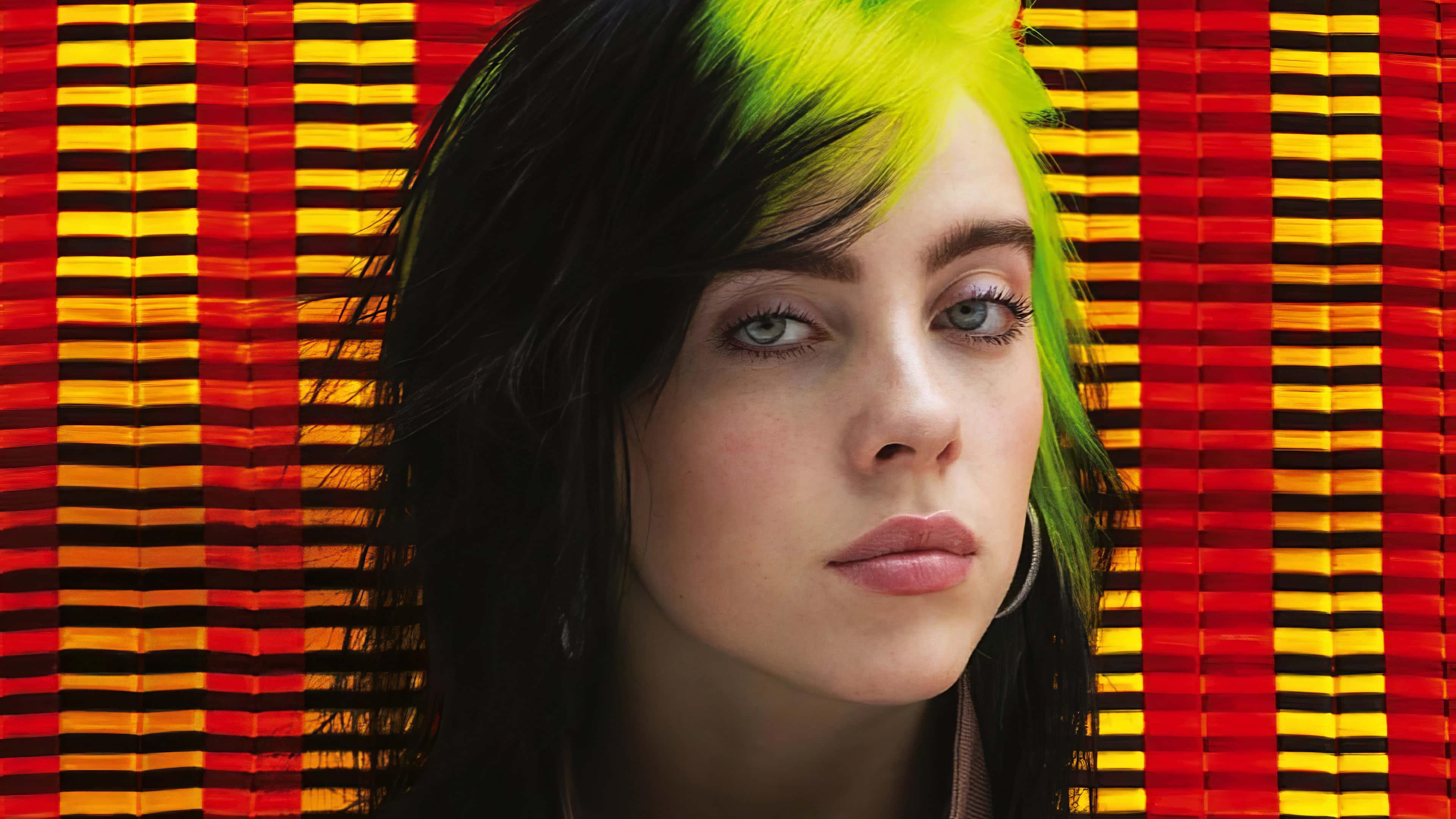 Billie Eilish Laptop 桌布 壁紙 — Billie Eilish 擁有螢光綠色頭髮，背景為大膽的紅黃條紋。