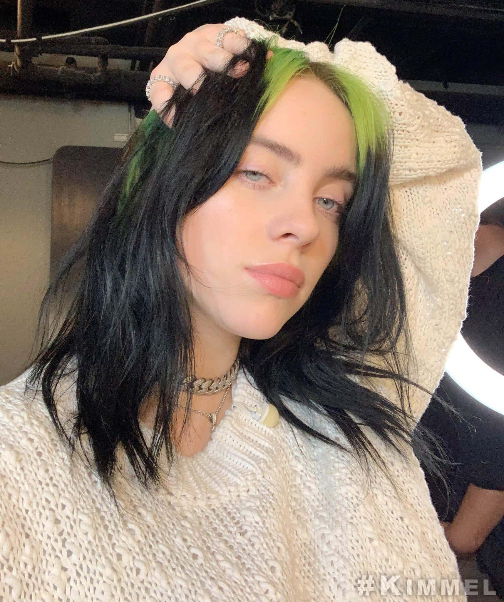 Billie Eilish 2021 桌布 壁紙 — Billie Eilish 擁有搶眼的綠色和黑色頭髮，身穿奶油色針織毛衣和銀色首飾，直視鏡頭。