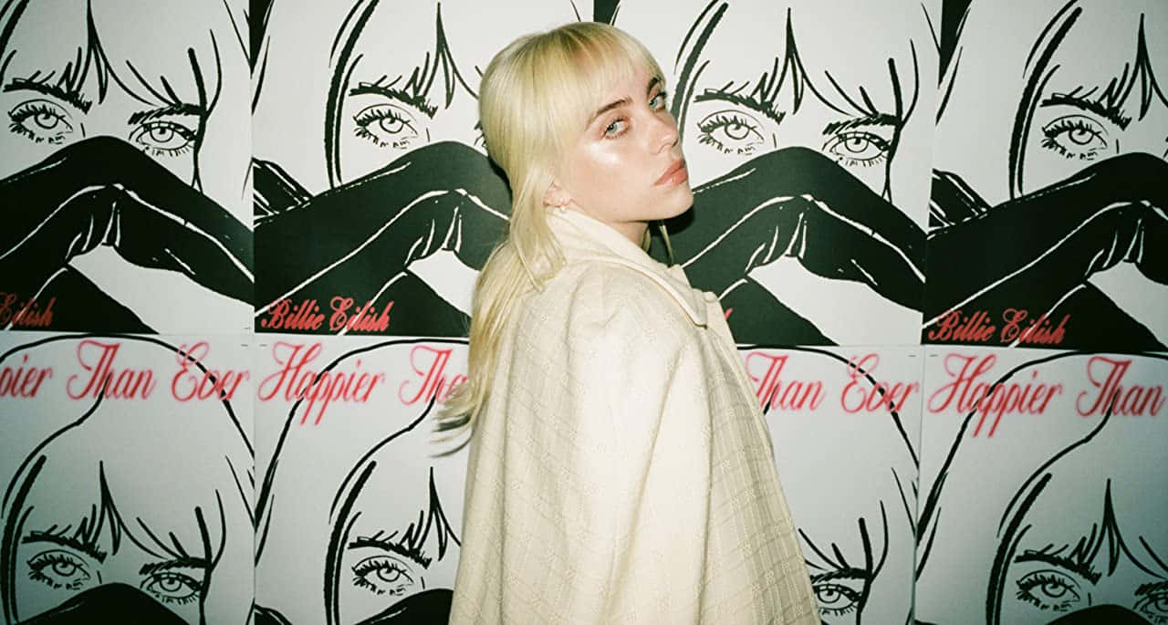 Billie Eilish Laptop 桌布 壁紙 — Billie Eilish 站在一面重複的黑白插圖牆前，牆上以紅色字體顯示她的臉和專輯標題。