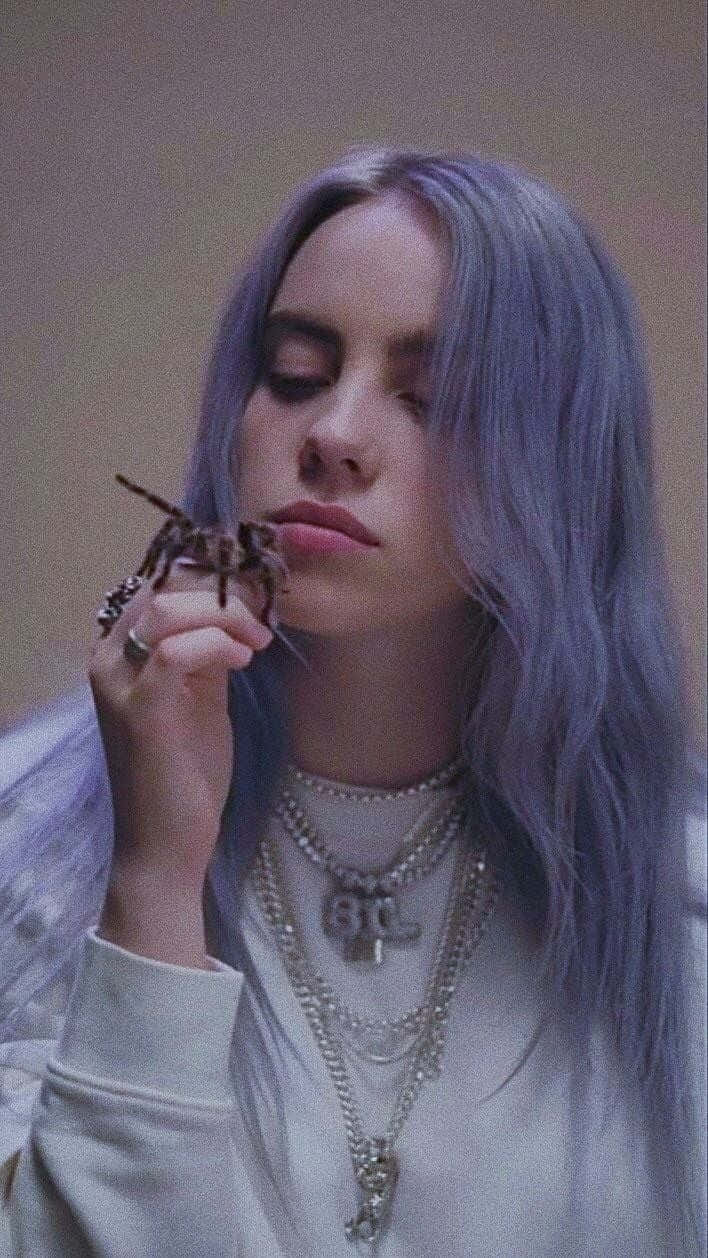 Billie Eilish Purple 桌布 壁紙 — Billie Eilish 薰衣草色頭髮，在陰鬱的特寫肖像中將狼蛛靠近臉部。