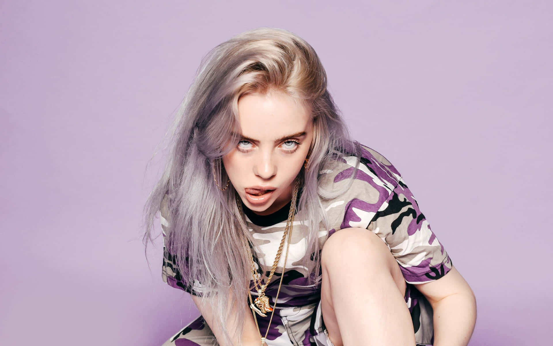 Billie Eilish Purple 桌布 壁紙 — Billie Eilish 蹲在薰衣草背景前，身穿紫色迷彩襯衫和金鏈。