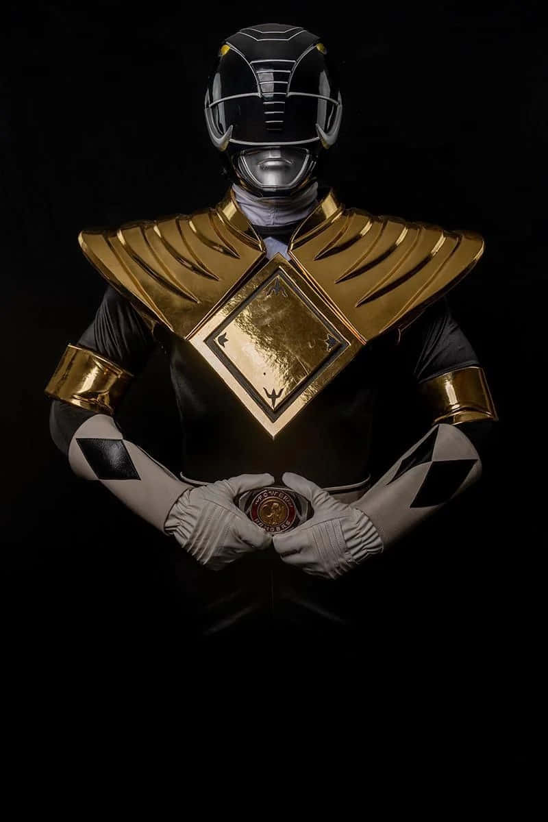  壁紙 — 一個黑金裝甲的Power Ranger站在深色背景前，戴著手套的手握著一枚硬幣。