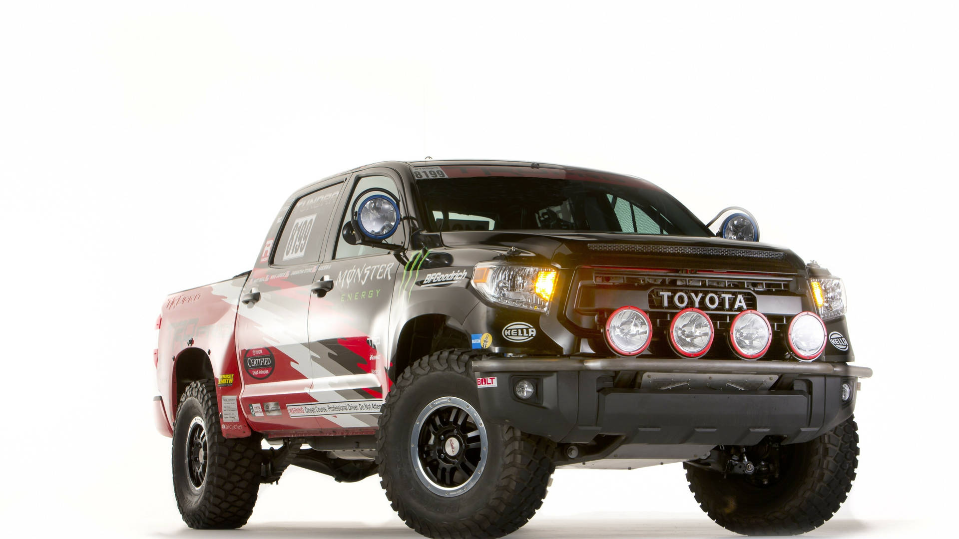 帶有Monster Energy貼紙和額外車頭燈的黑色和紅色豐田Tacoma越野卡車。 — Toyota Supra 壁紙