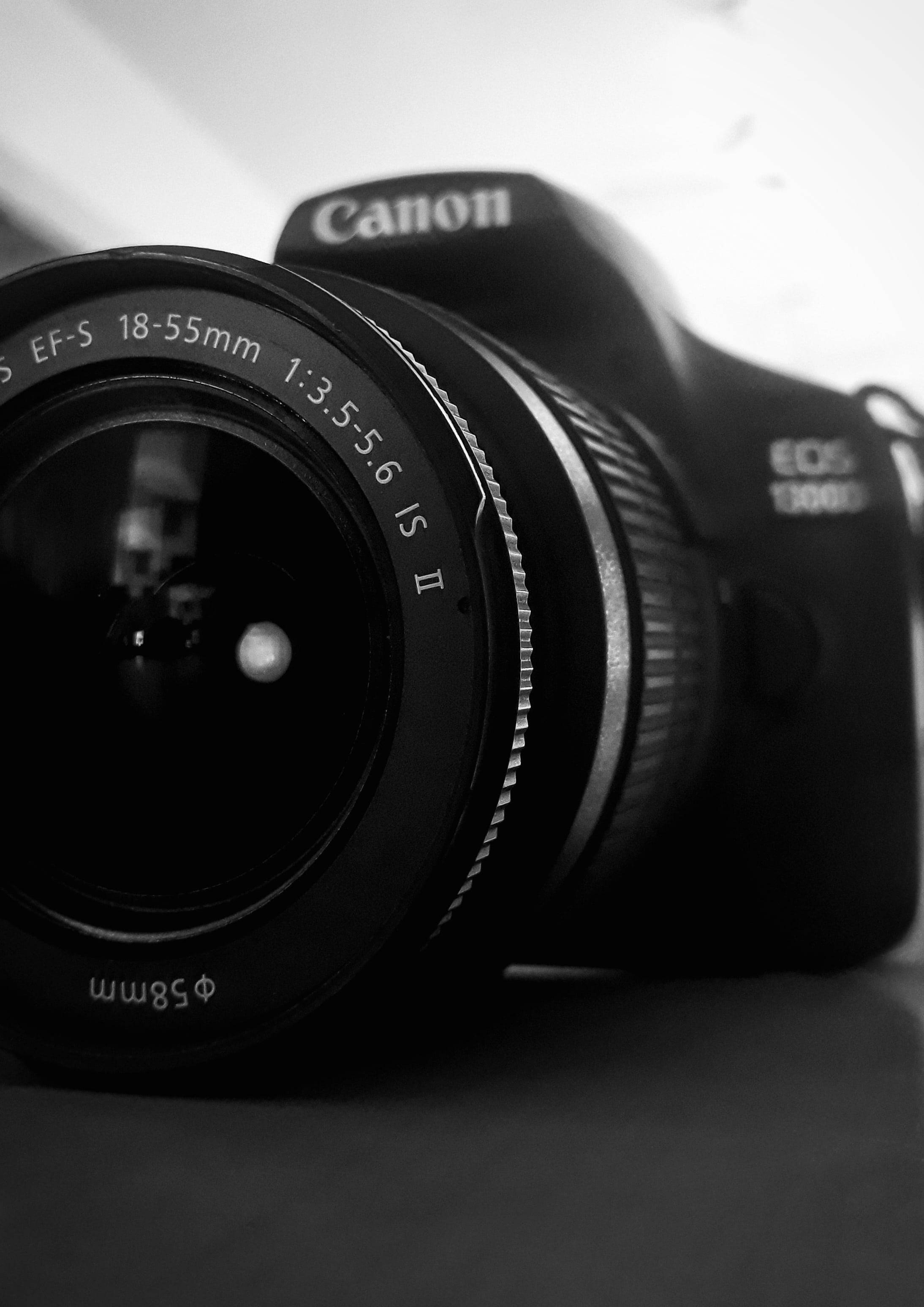 iPhone 桌布 壁紙 — Canon EOS 1300D 相機配備 EF-S 18-55mm 鏡頭放在表面上的黑白特寫。