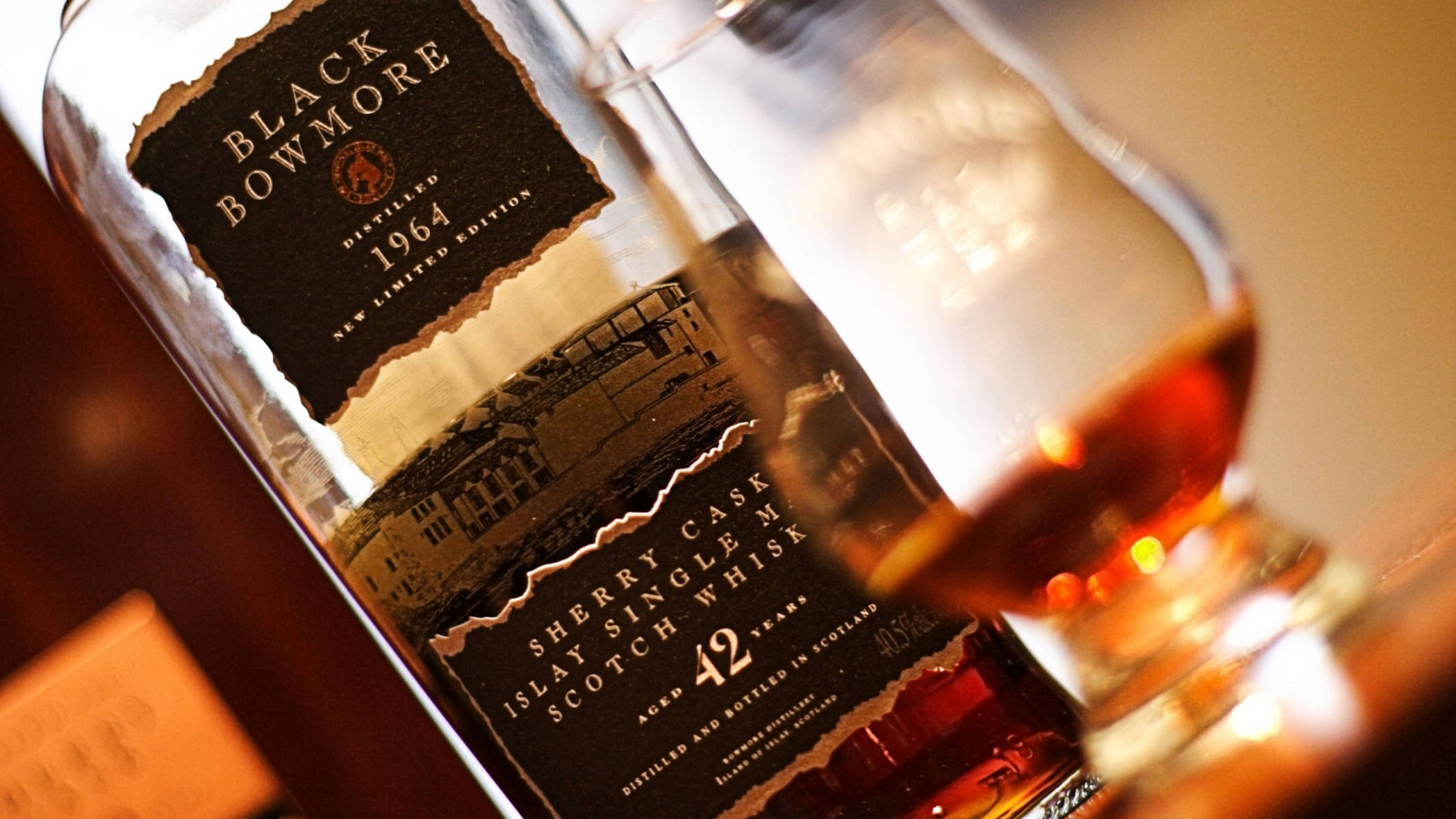 Whiskey 桌布 壁紙 — Black Bowmore 42年雪莉桶艾雷島單一麥芽威士忌酒瓶的特寫，旁邊放著一杯琥珀色液體。