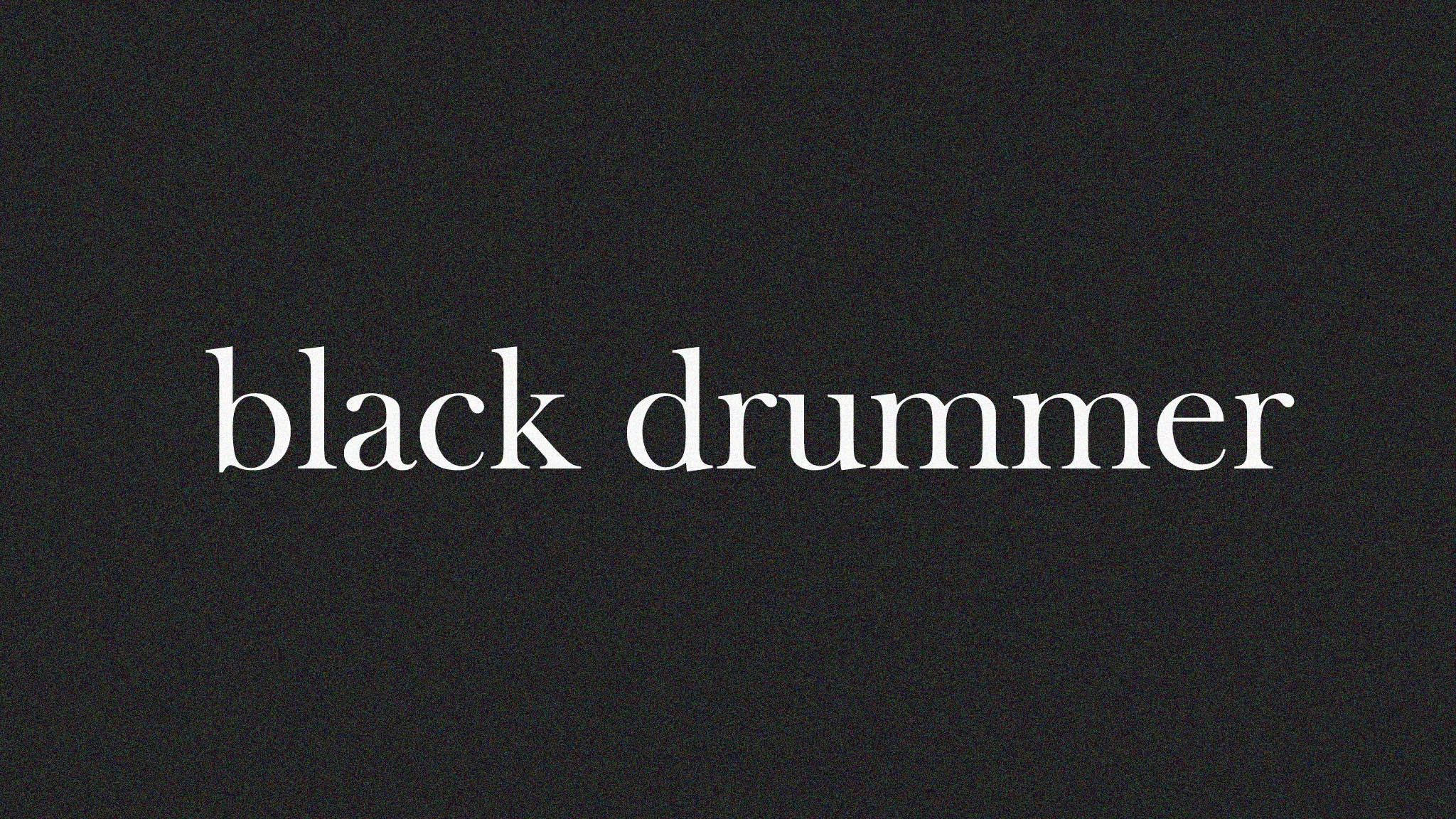 macbook pro aesthetic 桌布 壁紙 — 「black drummer」這幾個字以白色襯線字體置中在帶有紋理的深灰色背景上。