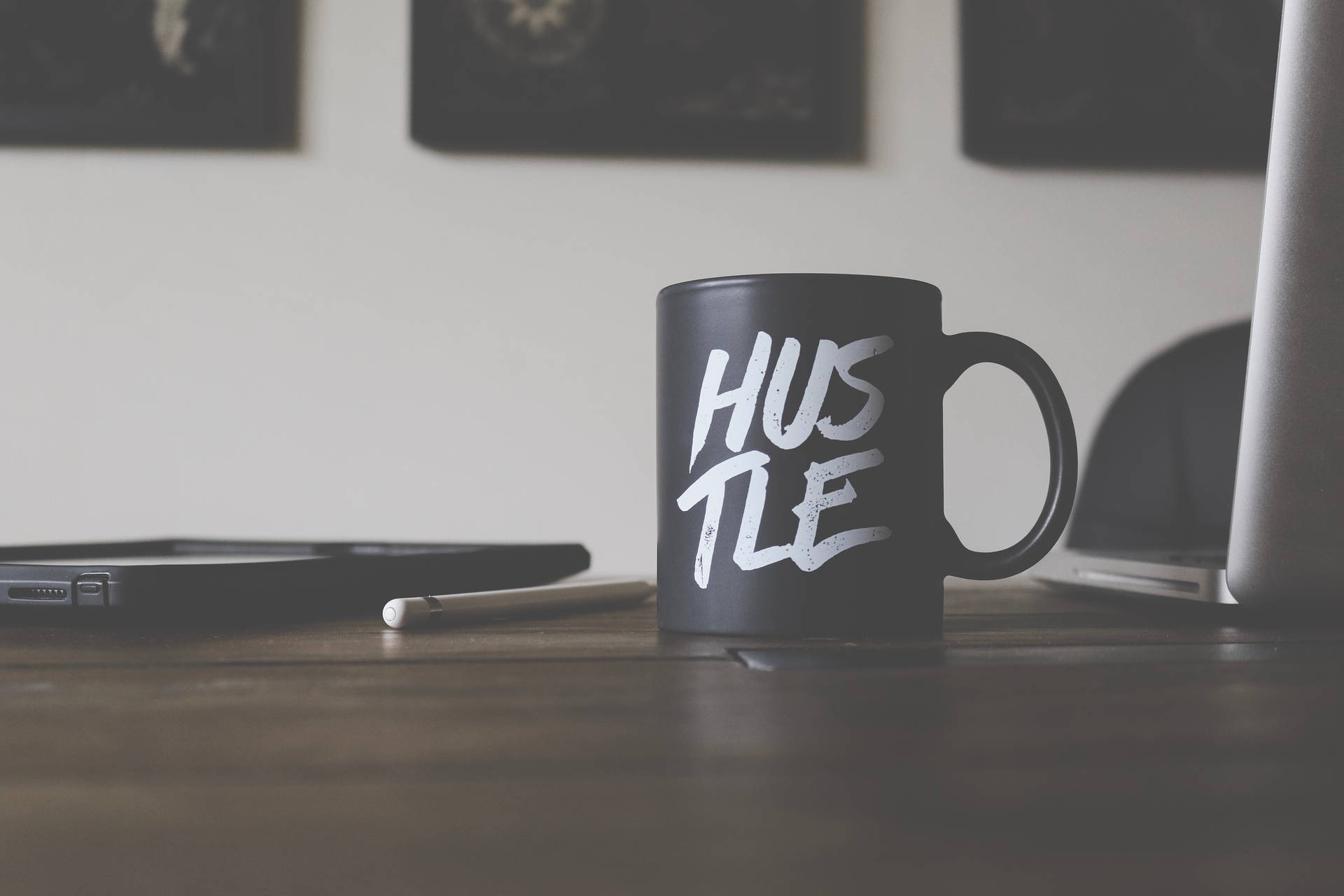 黑色馬克杯帶白色 hustle 文字，木桌上有筆記型電腦和平板電腦。 — 籃球激勵 壁紙