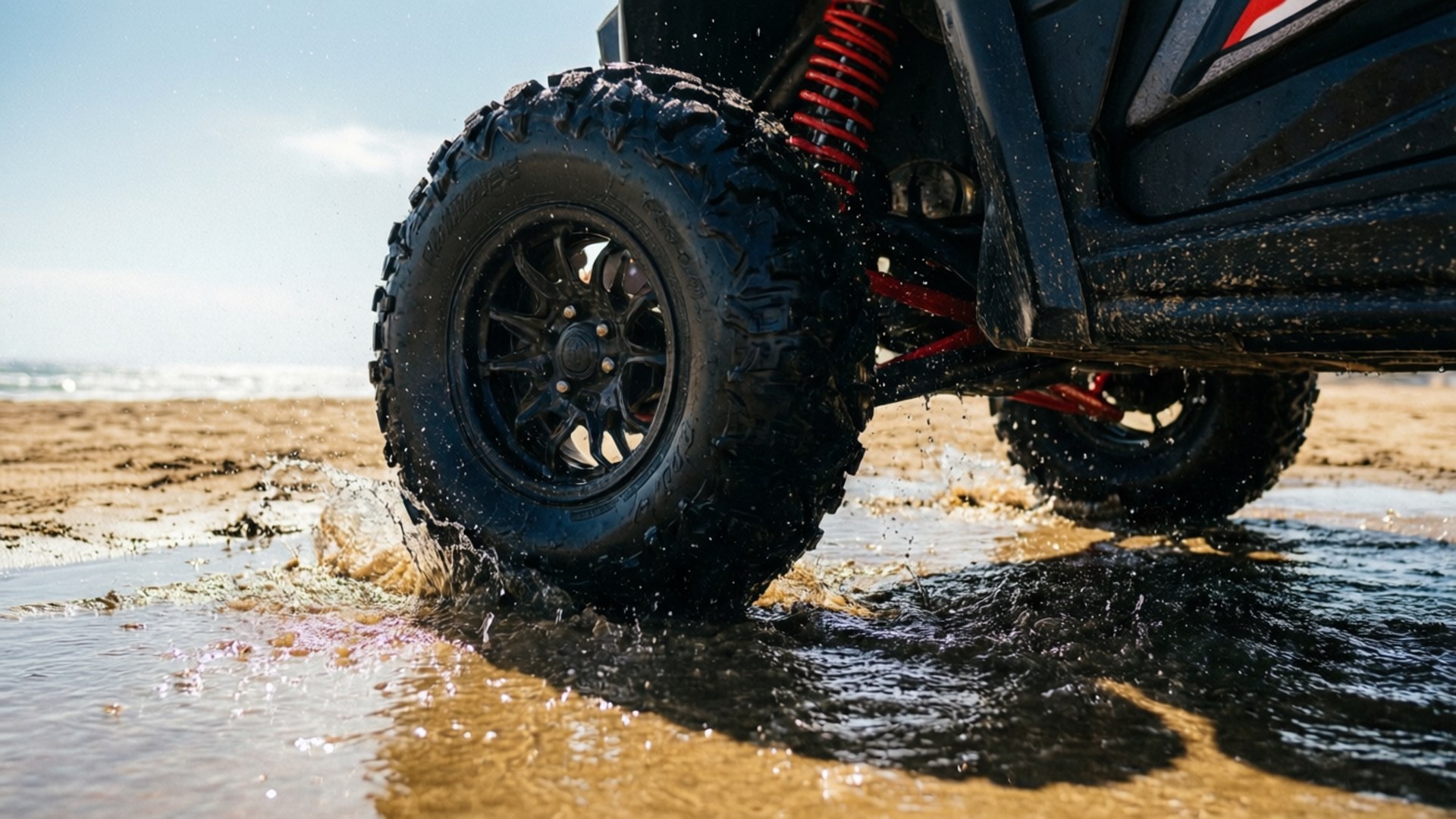 Beach Buggy Racing 桌布 壁紙 — 一輛黑色越野車配備紅色懸吊，在明亮的陽光下，在沙灘上濺起淺淺的海水。