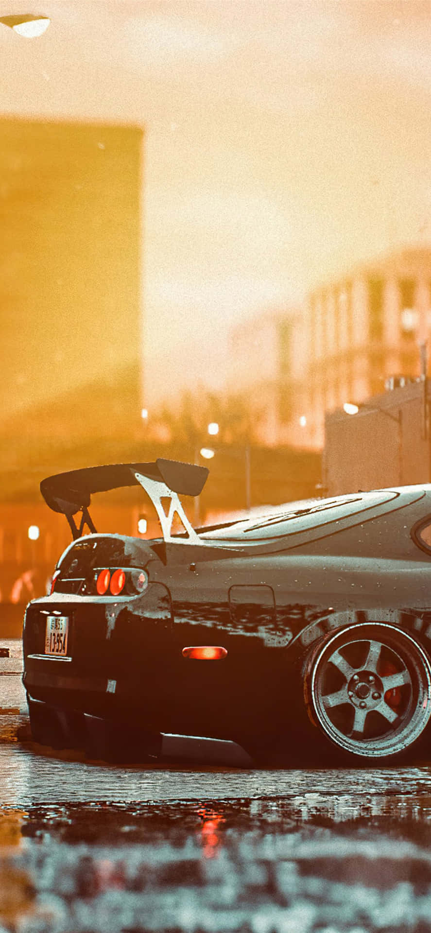 黑色跑車配後尾翼，停在夕陽下濕漉漉的城市街道上。 — Toyota Supra 壁紙