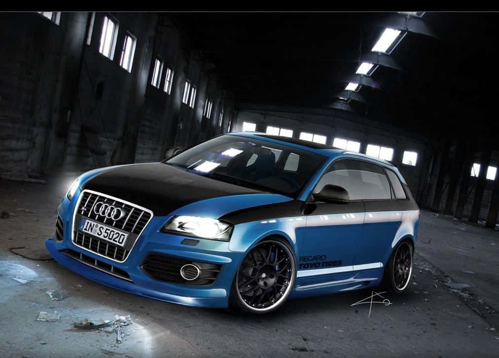 Audi S3 桌布 壁紙 — 一輛藍黑配色的Audi S5旅行車配備定制輪圈，在廢棄工業倉庫內刺眼的螢光燈下閃閃發光。