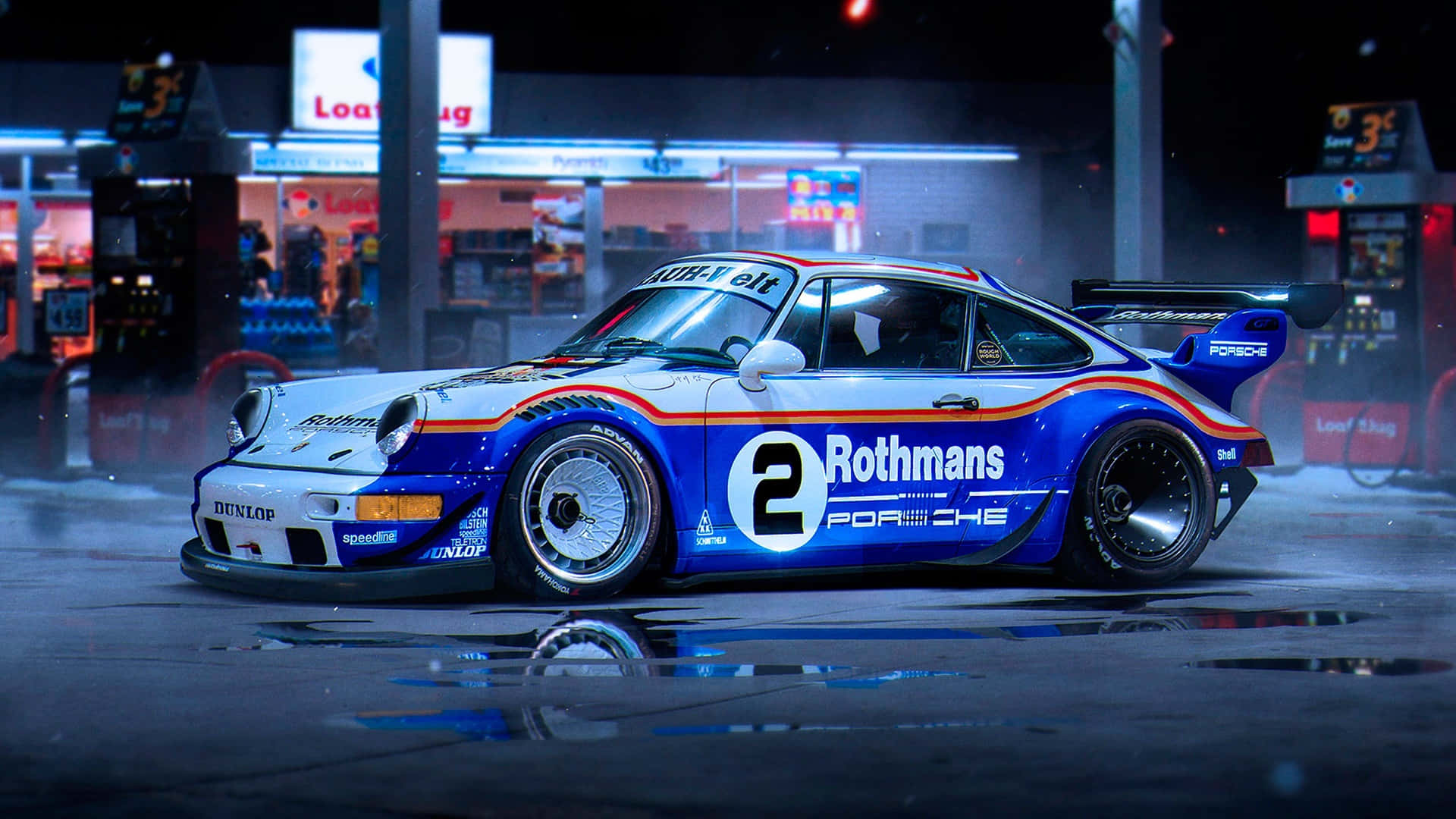  壁紙 — 一輛藍白色的 Rothmans Porsche 911 賽車在夜間濕漉漉的加油站霓虹燈下閃閃發光。